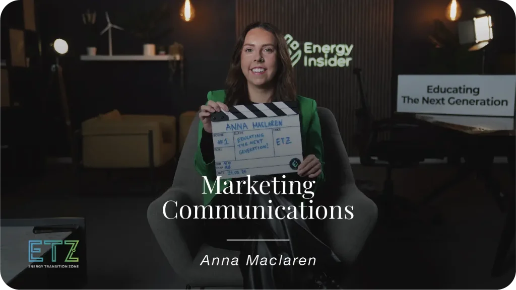 Anna Maclaren, a marketing and communications manager is sitting with a green jacket and smiling in a studio