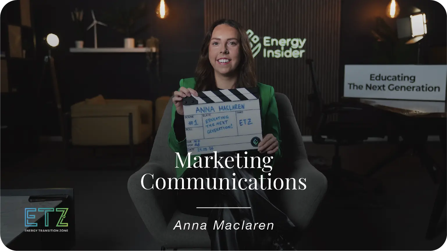 Anna Maclaren, a marketing and communications manager is sitting with a green jacket and smiling in a studio
