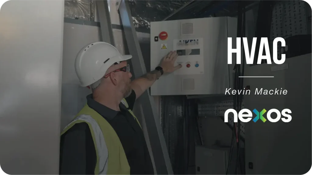 an HVAC technician working on a control panel.
